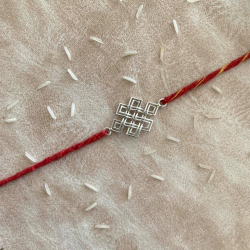 An Eternity Knot Silver Rakhi With Red Moli Thread